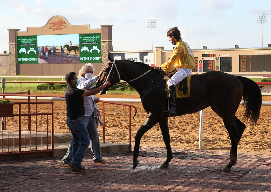 Jockey Keith Asmussen is greeted by his father Steve Asmussen after his first win with Inis Gluaire at Lone Star Park