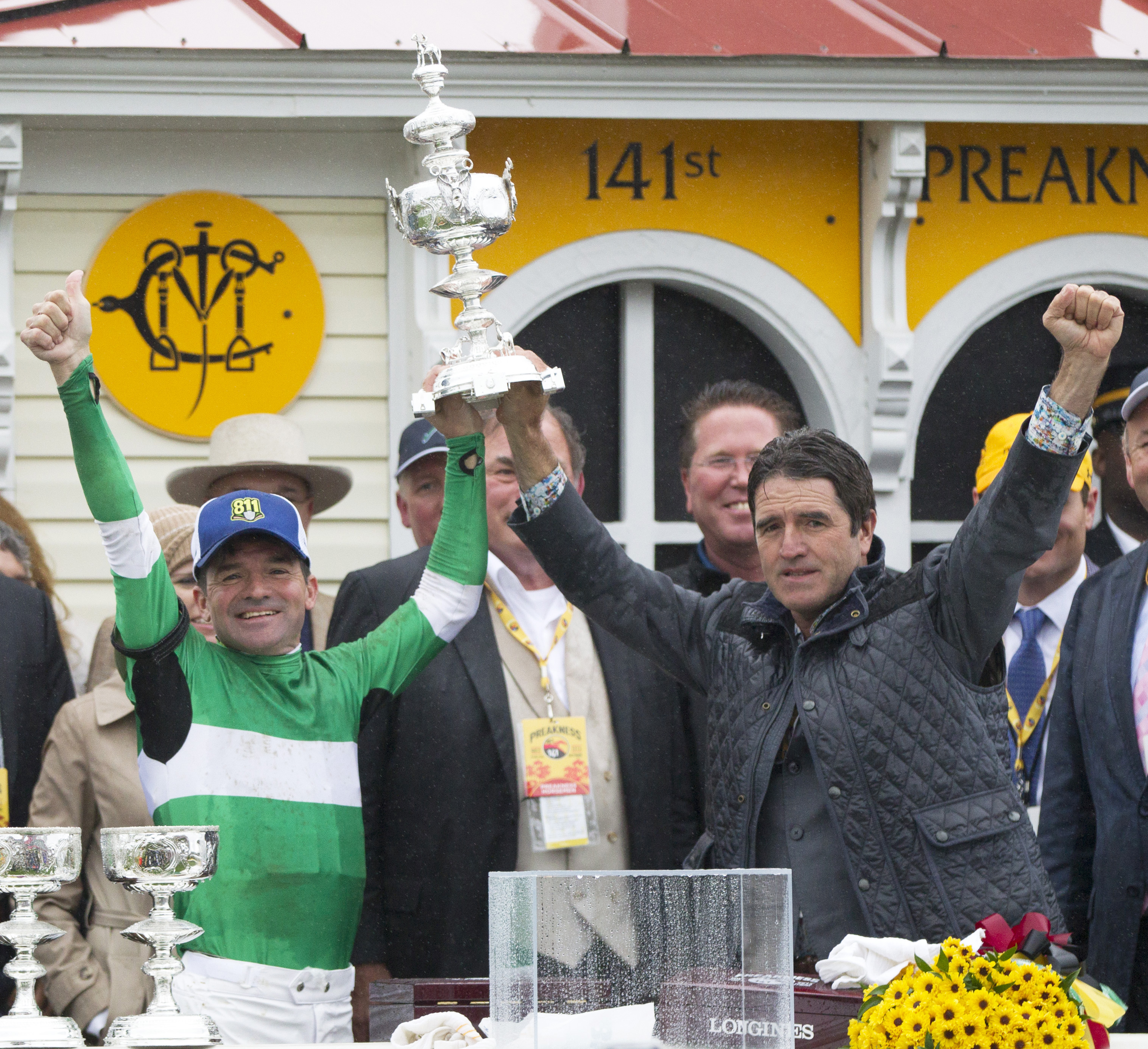 Kent and Keith Desormeaux raise the Preakness trophy