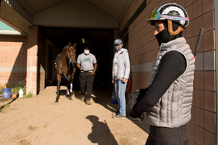 Jockey Luis Contreras (foreground) and trainer Josie Carroll (center) follow distancing protocol at Woodbine